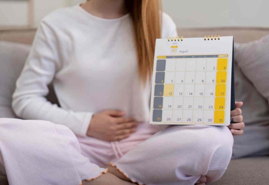 Fille sur un lit consultant un calendrier du cycle menstruel et son impact sur l'humeur.